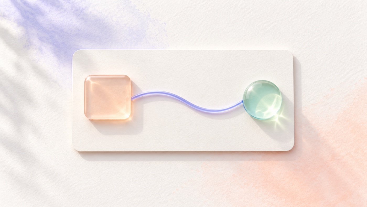 Un elemento in vetro color pesca è collegato da un filo pervinca a una conferma verde su una scheda di carta chiara.